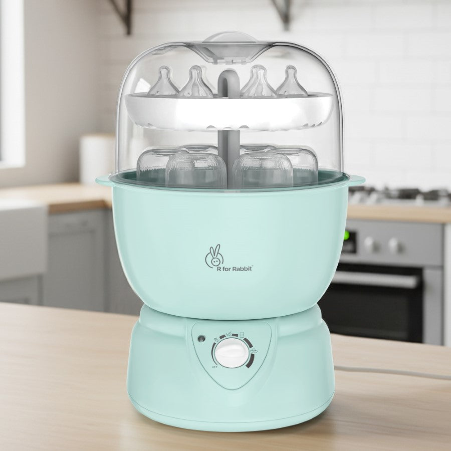 Mint green baby bottle sterilizer on a kitchen counter with 'R for Rabbit' branding.