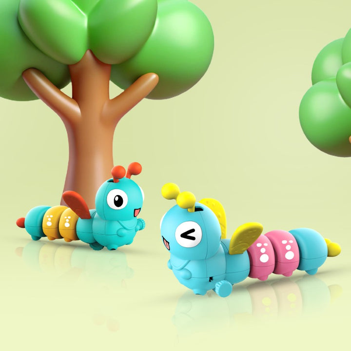 Colorful toy caterpillars on a reflective surface with a green tree in the background